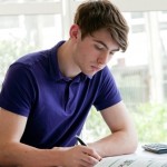 student studying at desk with textbook and calculator