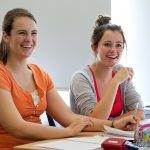 female students at desk laughing