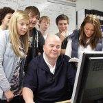 Students gathered round tutors computer screen