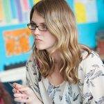 female student wearing glasses and holding pen during revision session