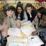 Students gathered round a desk studying together