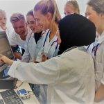 Medicine students gathered round computer screen