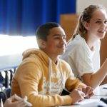 Students smiling sitting at desks