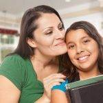 Parent hugging and supporting child student holding books